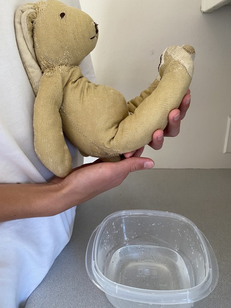Wash baby from a holding position.